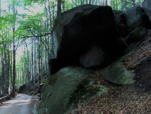 Obří balvany hrozivě visí nad stezkou.