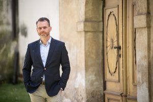 Adam Viktora před dveřmi kostela ve Smečně