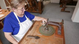 Blanka Hakenová předvádí starý způsob broušení pomocí kvadrantu v expozici muzea.